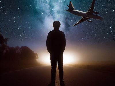 شخصی میانه راه ایستاده و آسمان و ماه و کهکشان را نگاه می‌کند و هواپیما هم در حال گذر از آسمان بالای سر است.